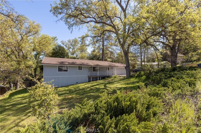 rear view of house with a lawn and a garage
