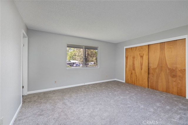unfurnished bedroom with a closet, a textured ceiling, and carpet