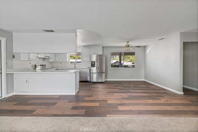 kitchen featuring visible vents, a peninsula, ceiling fan, a textured ceiling, and appliances with stainless steel finishes