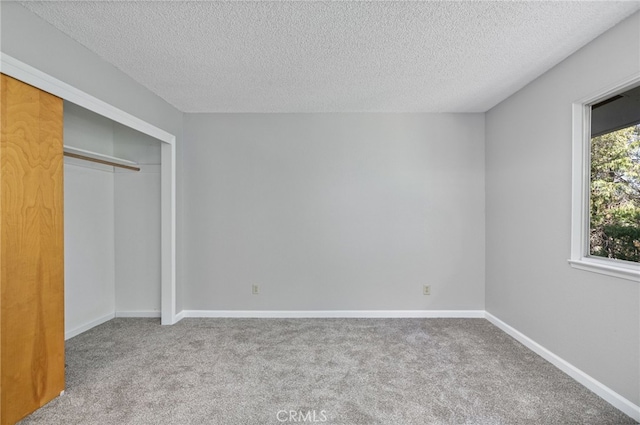 unfurnished bedroom with a closet, carpet flooring, and a textured ceiling