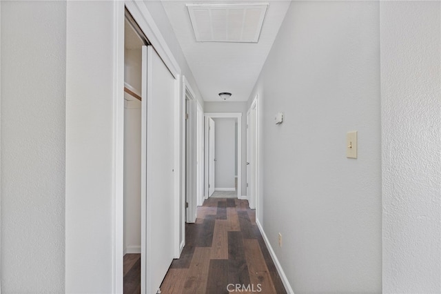 hall with baseboards, dark wood-type flooring, and visible vents