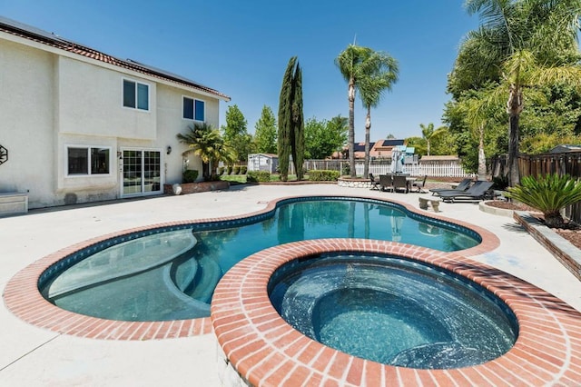 view of swimming pool with a pool with connected hot tub, a fenced backyard, and a patio area
