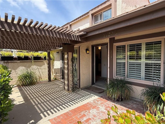 25723 Player Dr, Valencia, CA 91355 - view of exterior entry featuring a pergola, stucco siding, and a patio area