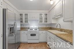 25723 Player Dr, Valencia, CA 91355 - kitchen with white appliances, white cabinets, a sink, and glass insert cabinets
