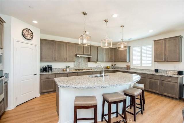 11534 Alana Ln, Beaumont, CA 92223 - kitchen featuring a kitchen island with sink, stainless steel gas cooktop, a sink, recessed lighting, and a kitchen bar