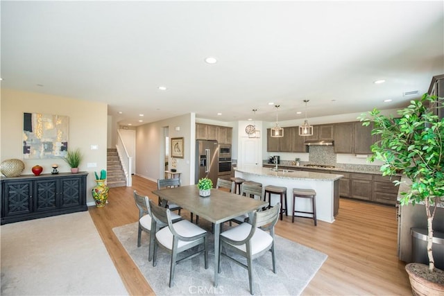 11534 Alana Ln, Beaumont, CA 92223 - dining room featuring baseboards, stairs, light wood finished floors, and recessed lighting
