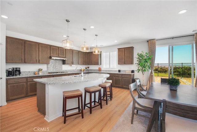 11534 Alana Ln, Beaumont, CA 92223 - kitchen featuring a sink, stainless steel gas cooktop, light wood-type flooring, under cabinet range hood, and recessed lighting