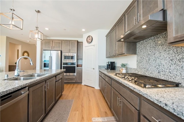11534 Alana Ln, Beaumont, CA 92223 - kitchen with light wood finished floors, exhaust hood, stainless steel appliances, a sink, and tasteful backsplash