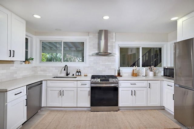 1105 Fulton Rd, San Marcos, CA 92069 - kitchen with stainless steel appliances, a sink, backsplash, white cabinetry, and wall chimney range hood