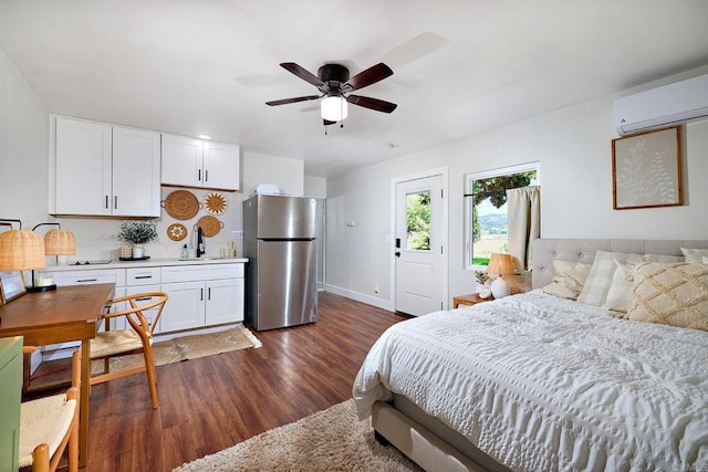 1105 Fulton Rd, San Marcos, CA 92069 - bedroom featuring baseboards, freestanding refrigerator, an AC wall unit, and dark wood-style flooring