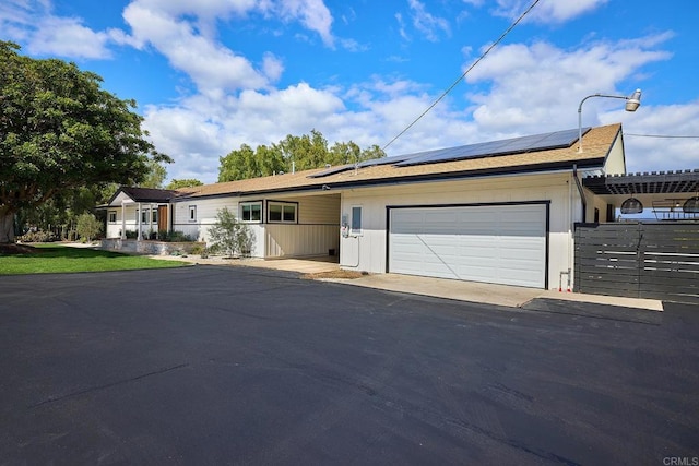 1105 Fulton Rd, San Marcos, CA 92069 - ranch-style house with roof mounted solar panels, aphalt driveway, fence, and a garage