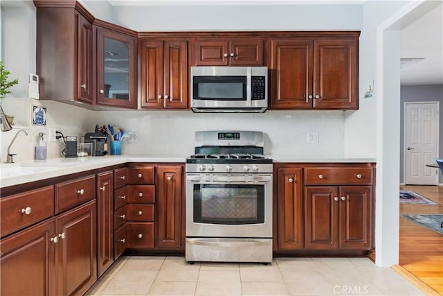4723 E 3rd St, Long Beach, CA 90814 - kitchen with a sink, glass insert cabinets, stainless steel appliances, light countertops, and backsplash