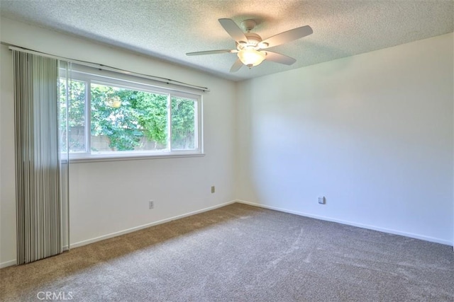 carpeted empty room with a ceiling fan, a textured ceiling, and baseboards