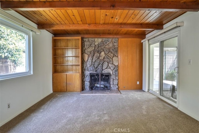 unfurnished living room with carpet flooring, wooden ceiling, beam ceiling, and a fireplace