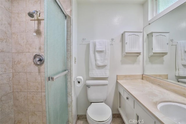bathroom featuring vanity, tile patterned flooring, a stall shower, and toilet