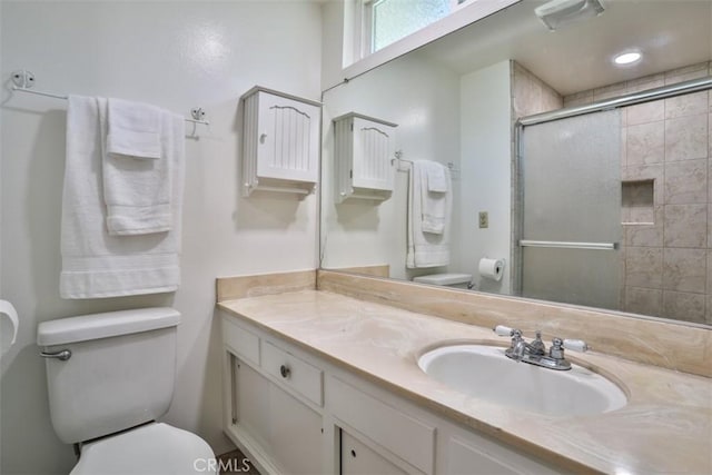 bathroom featuring toilet, visible vents, a tile shower, and vanity