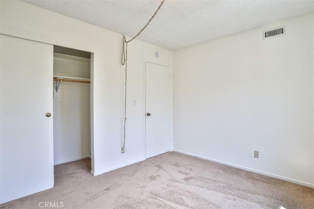 unfurnished bedroom with visible vents, carpet floors, a closet, baseboards, and a textured ceiling