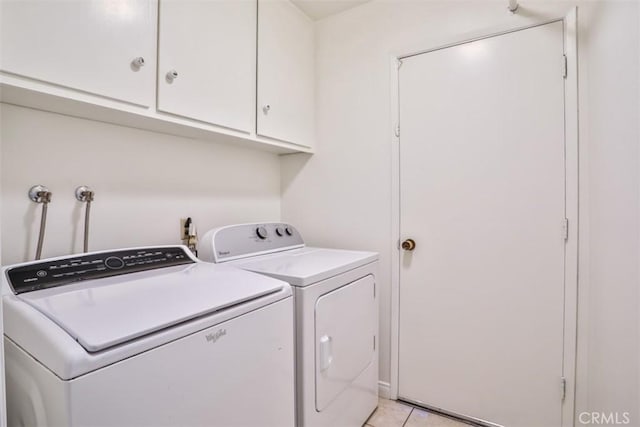 laundry area with separate washer and dryer, cabinet space, and light tile patterned flooring