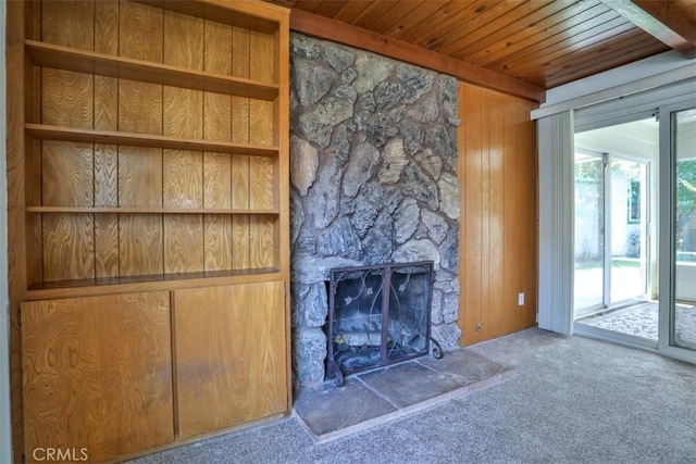 unfurnished living room with carpet flooring, wood ceiling, and wooden walls