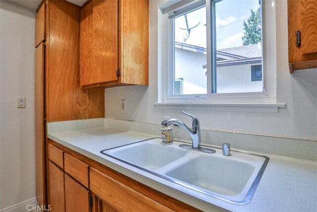 11722 Pickering Way, El Monte, CA 91732 - kitchen with a sink, light countertops, and brown cabinetry