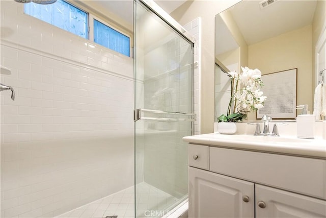 bathroom featuring visible vents, vanity, and a stall shower