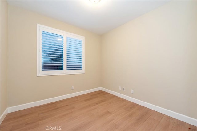 empty room featuring light wood-style flooring and baseboards