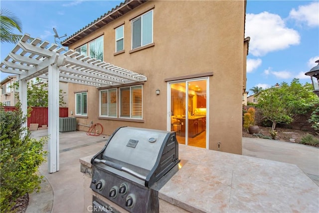 exterior space with stucco siding, fence, a pergola, and a patio