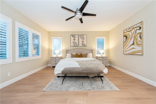 bedroom with ceiling fan, light wood-style flooring, and baseboards