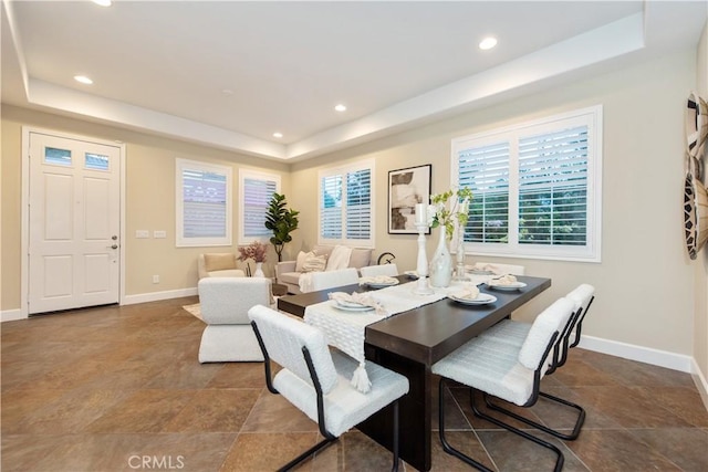 dining area featuring recessed lighting, a tray ceiling, and baseboards