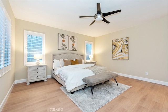 bedroom featuring baseboards, ceiling fan, and light wood-style flooring