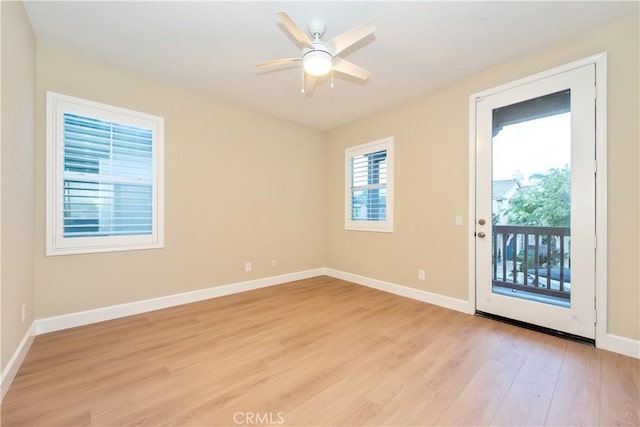 spare room featuring baseboards, a ceiling fan, and light wood finished floors