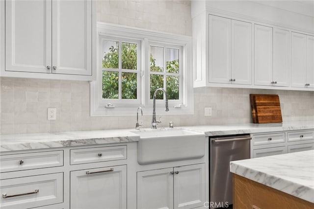 kitchen with white cabinets, dishwasher, a sink, and tasteful backsplash