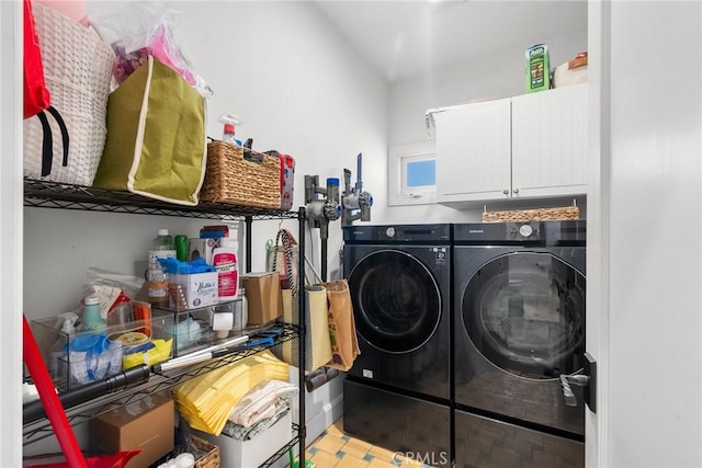 clothes washing area with washing machine and dryer and cabinet space