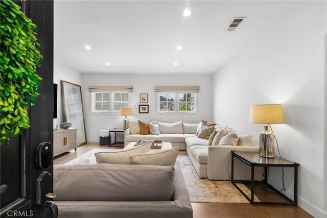 living area with baseboards, wood finished floors, visible vents, and recessed lighting