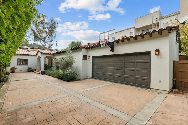 view of front of home featuring stucco siding, decorative driveway, and a garage