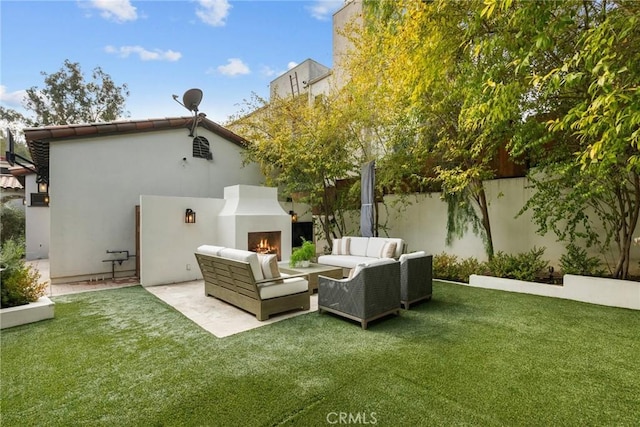 back of house featuring an outdoor living space with a fireplace, a patio area, a fenced backyard, and a yard