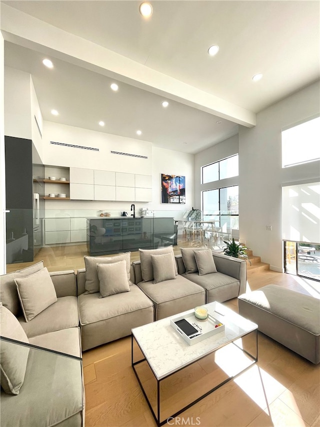 living area featuring beam ceiling and recessed lighting
