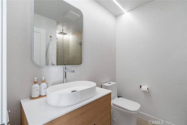bathroom featuring a stall shower, vanity, and toilet