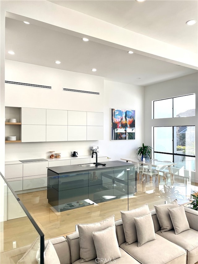 interior space with a sink, recessed lighting, light wood finished floors, white cabinets, and modern cabinets