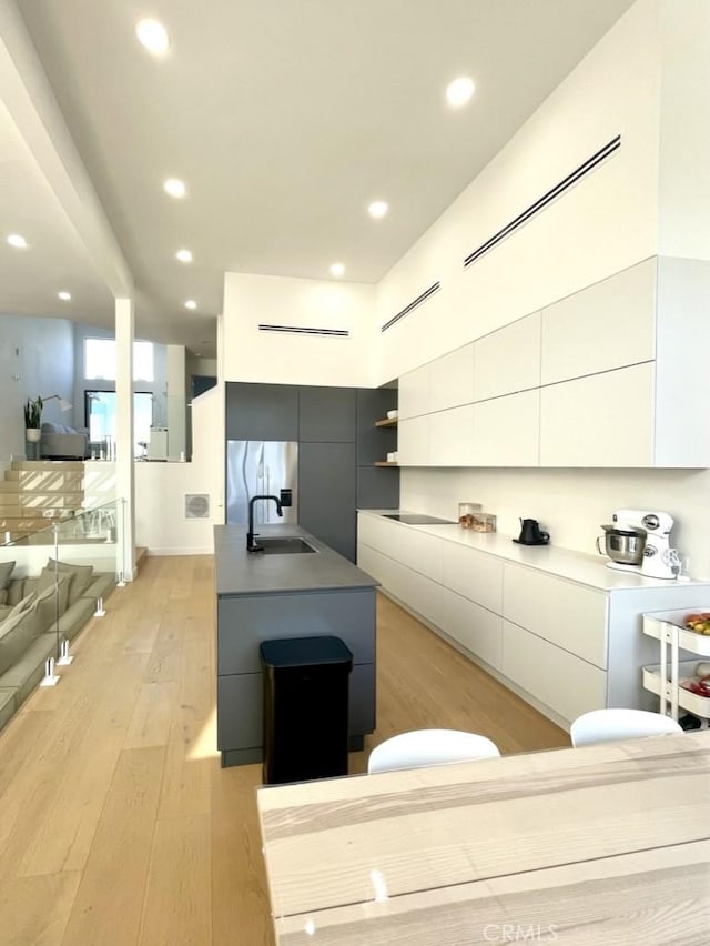 kitchen with light wood-style floors, modern cabinets, open shelves, and white cabinets