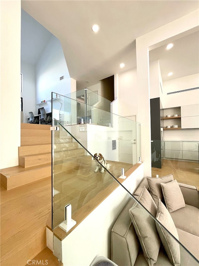 stairway with wood finished floors, visible vents, and recessed lighting
