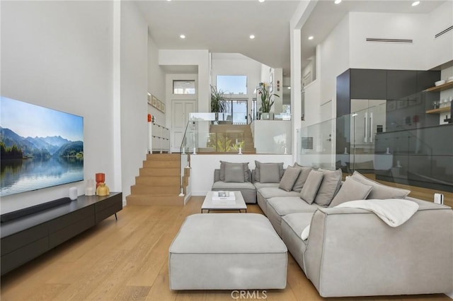 15 Waterway Unit 11, Irvine, CA 92614 - living area with light wood-style flooring, a high ceiling, recessed lighting, and stairway