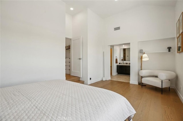 15 Waterway Unit 11, Irvine, CA 92614 - bedroom featuring wood finished floors, a high ceiling, baseboards, ensuite bathroom, and recessed lighting