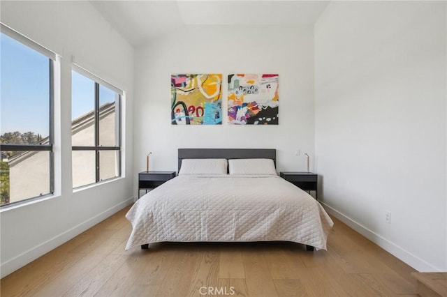 15 Waterway Unit 11, Irvine, CA 92614 - bedroom featuring multiple windows, baseboards, wood finished floors, and lofted ceiling