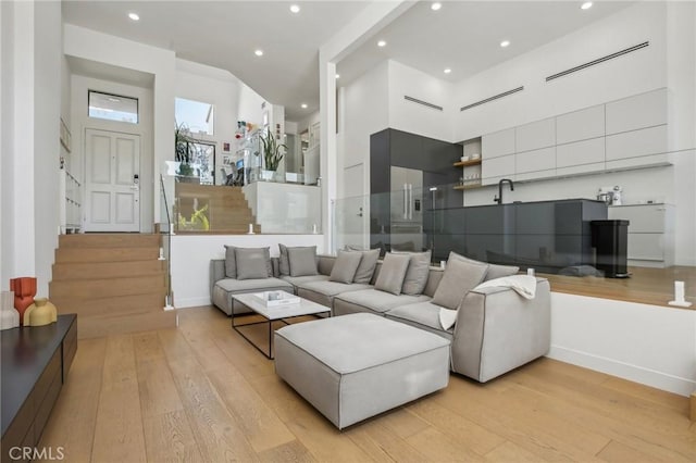 15 Waterway Unit 11, Irvine, CA 92614 - living room featuring light wood-style flooring, recessed lighting, stairway, and baseboards