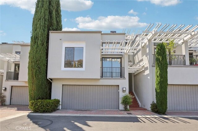 15 Waterway Unit 11, Irvine, CA 92614 - townhome / multi-family property featuring a pergola, stucco siding, a garage, and decorative driveway
