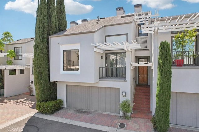 15 Waterway Unit 11, Irvine, CA 92614 - view of front of property with a chimney, stucco siding, and a garage
