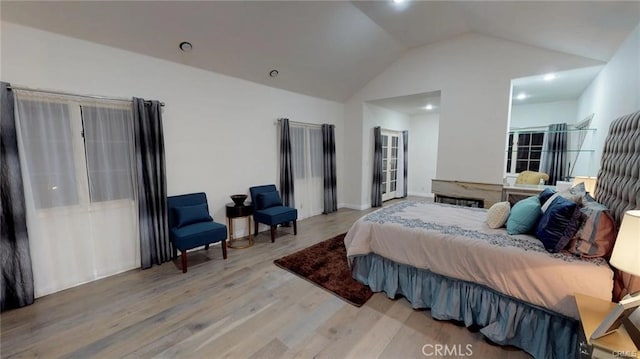 bedroom featuring lofted ceiling and light wood-style flooring