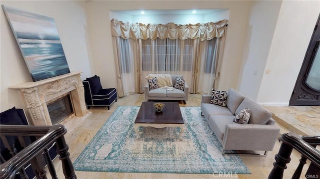living room with baseboards and a high end fireplace