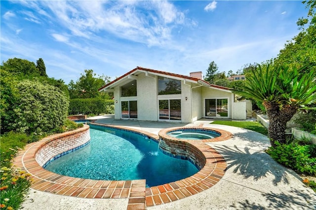 view of swimming pool featuring a patio and a pool with connected hot tub